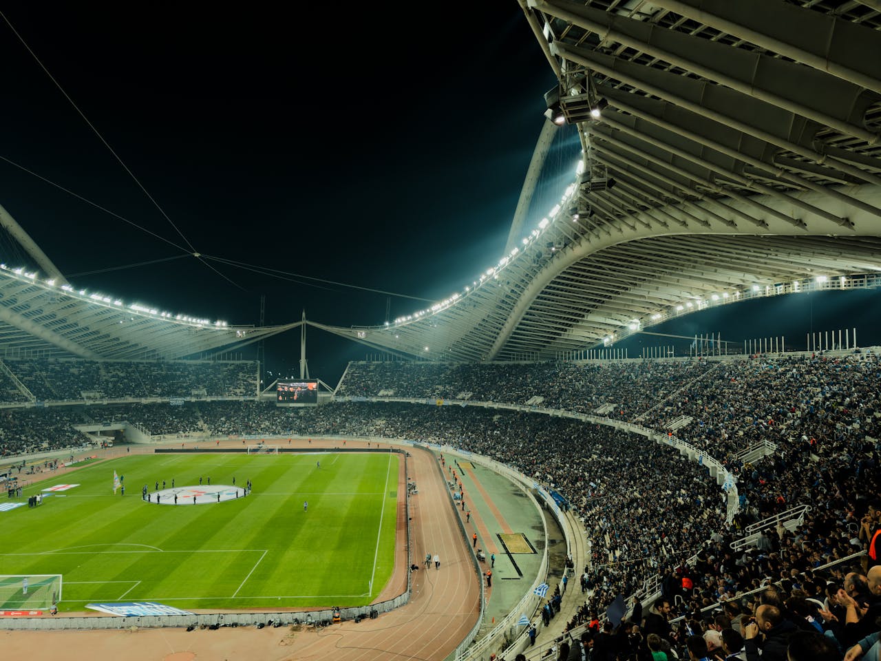 ours-journey A crowded soccer stadium under bright lights at night, capturing the excitement of a live sports event.